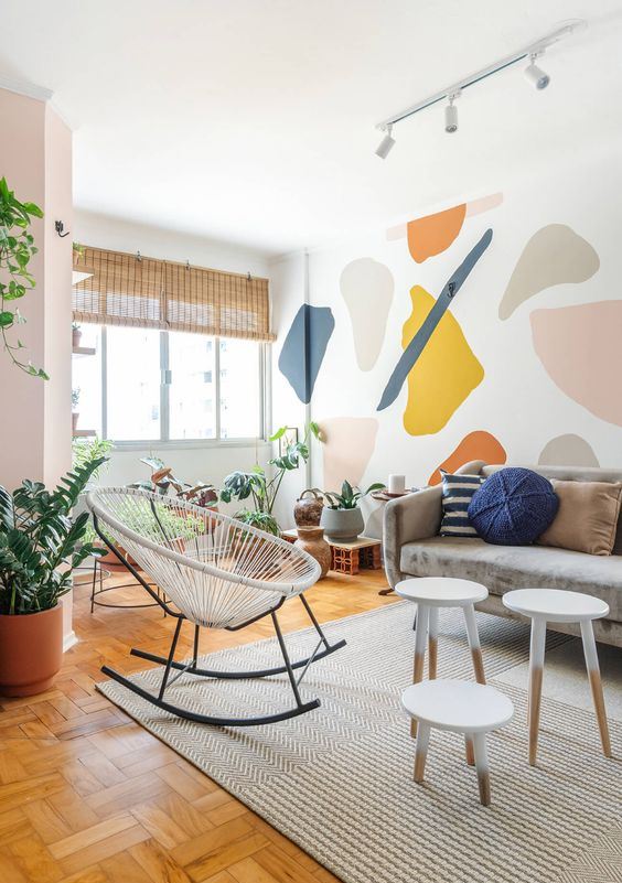 a modern and airy living room with a bold terrazzo accent wall that brings a fun and colorful touch to the space