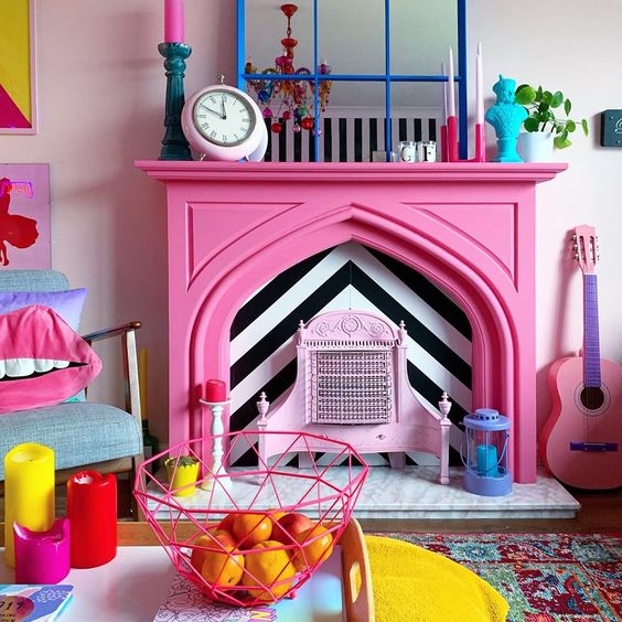 a quirky colorful living room finished off with a hot pink faux fireplace with colorful accessories on the mantel