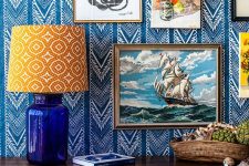 26 refined bold blue and white printed wallpaper and a gallery wall on it plus a printed lamp for a bright and eye-catchy nook