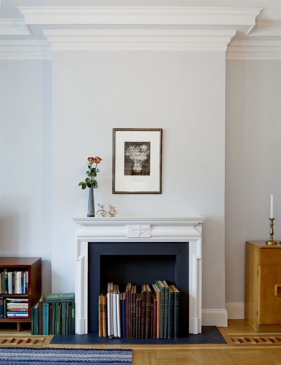 a French fireplace with large books inside that turn this fireplace into a lovely and unusual display