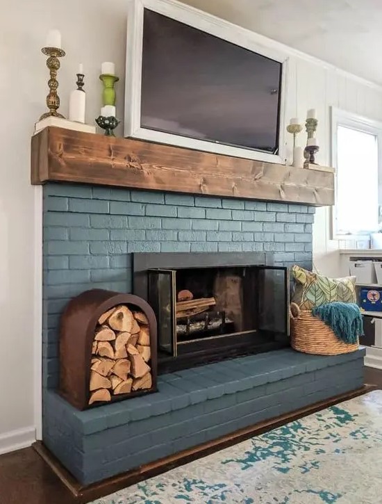 - تصآميم مدفأة ملونة انيقة .. ! A-blue-brick-fireplace-is-lovely-finished-off-with-a-wooden-mantel-and-accented-with-a-basket-with-towels-and-a-firewood-storage