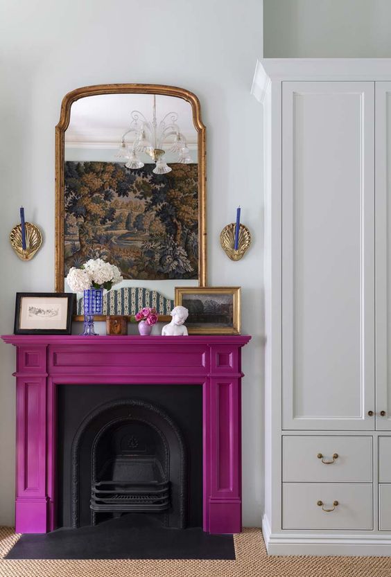 a cast iron fireplace wiht a purple mantel, some vintage decor on it is a cool color accent for the space