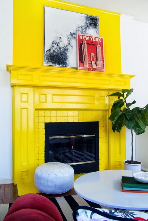 a fireplace clad with yellow tile, with a yellow mantel on top is a cool and bold solution for a living room