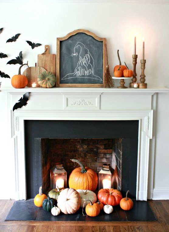 a fireplace with colorful pumpkins and candle lanterns easily turned into a Halloween one with black paper bats attached