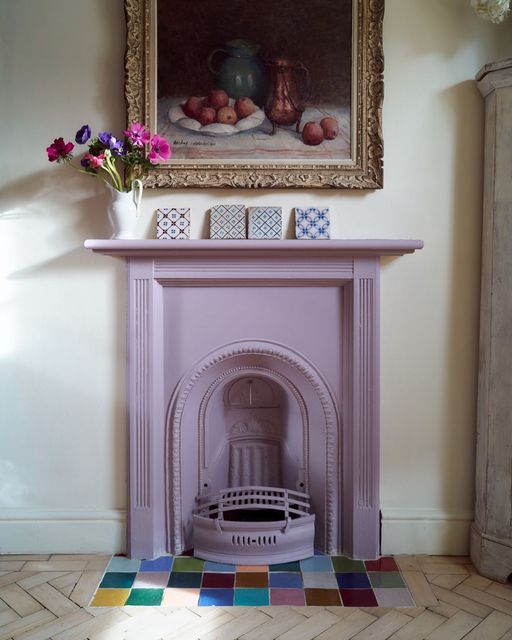 a lilac cast iron fireplace and bold tiles in front of it is a super cool combination and an unexpected solution to rock