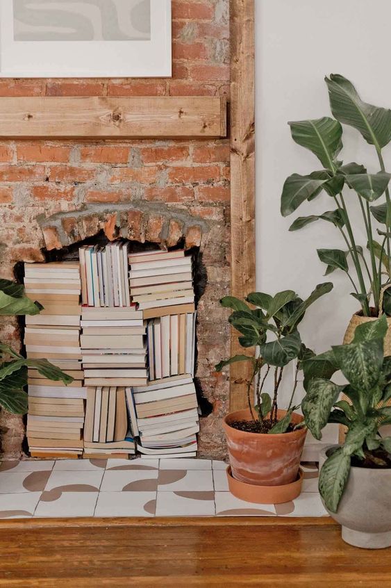 a non-working brick fireplace with boks stored and potted plants is a cool idea to add interest to a space