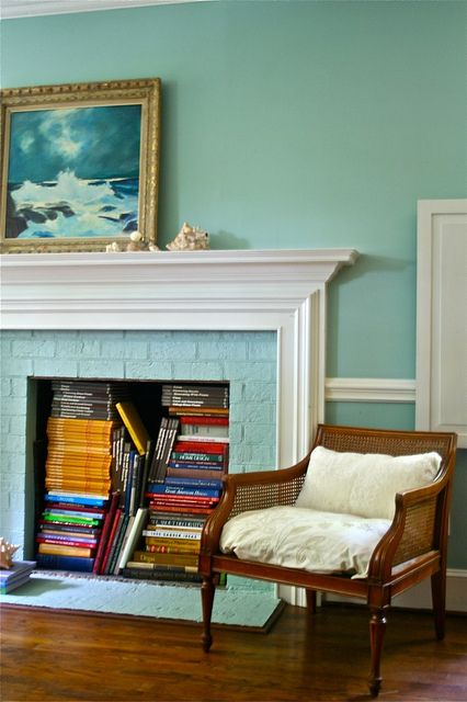 a non-working fireplace with bright books inside is a cool solution to use a piece that doesn't work