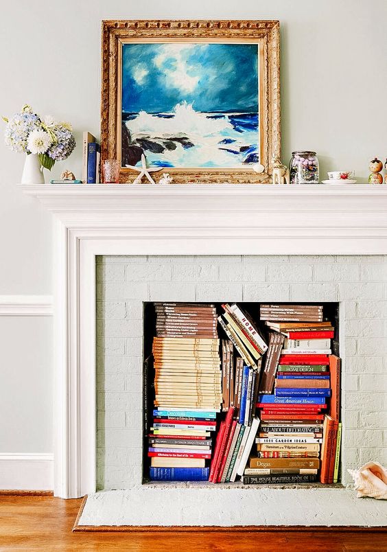 a non-working fireplace with magazines and books inside is a cool idea for storage, these books also add some color