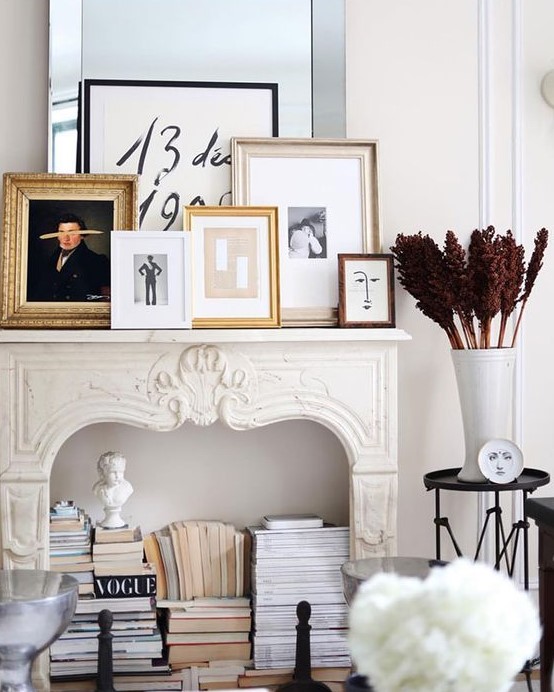 a refined fireplace with a gallery wall on the mantel, with books and statues inside it is a very chic and cool idea