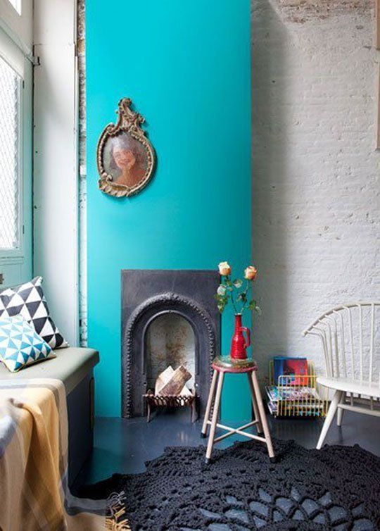 a vintage cast iron fireplace with a turquoise surround is a super bright and cool idea for a modern living room