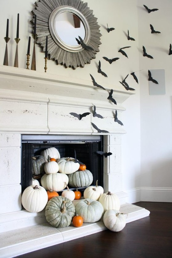 simple fireplace styling with heirloom pumpkins on stands is turned Halloween with simple black paper bats attached to the side