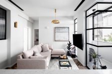 02 The living room features a blush sectional, a statement artwork, brass touches and an entrance to the balcony