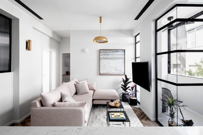 The living room features a blush sectional, a statement artwork, brass touches and an entrance to the balcony The living room features a blush sectional, a statement artwork, brass touches and an entrance to the balcony