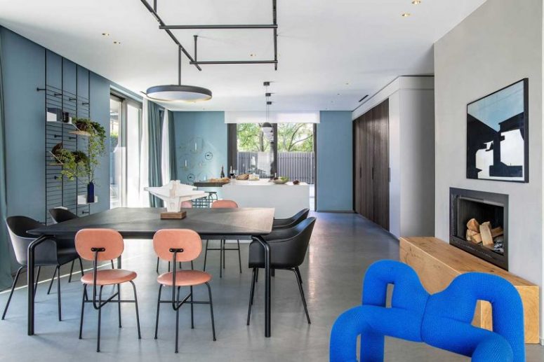 The main layout is an open space with a kitchen, dining room and a living room, with blue walls and catchy pendant lamps The main layout is an open space with a kitchen, dining room and a living room, with blue walls and catchy pendant lamps