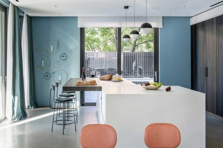 The kitchen is done with dark wooden storage units instead of traditional cabinets, and a large kitchen island with a bar zone The kitchen is done with dark wooden storage units instead of traditional cabinets, and a large kitchen island with a bar zone