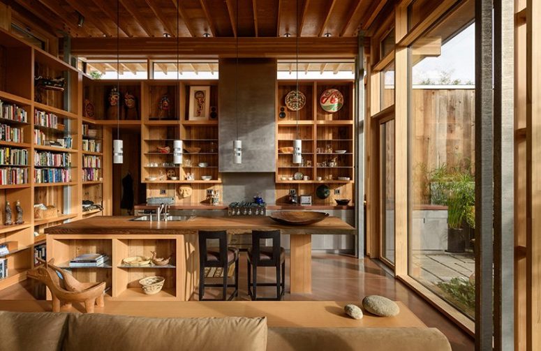 The kitchen is done with lots of open shelving and a large kitchen island of wood with a place for meals The kitchen is done with lots of open shelving and a large kitchen island of wood with a place for meals