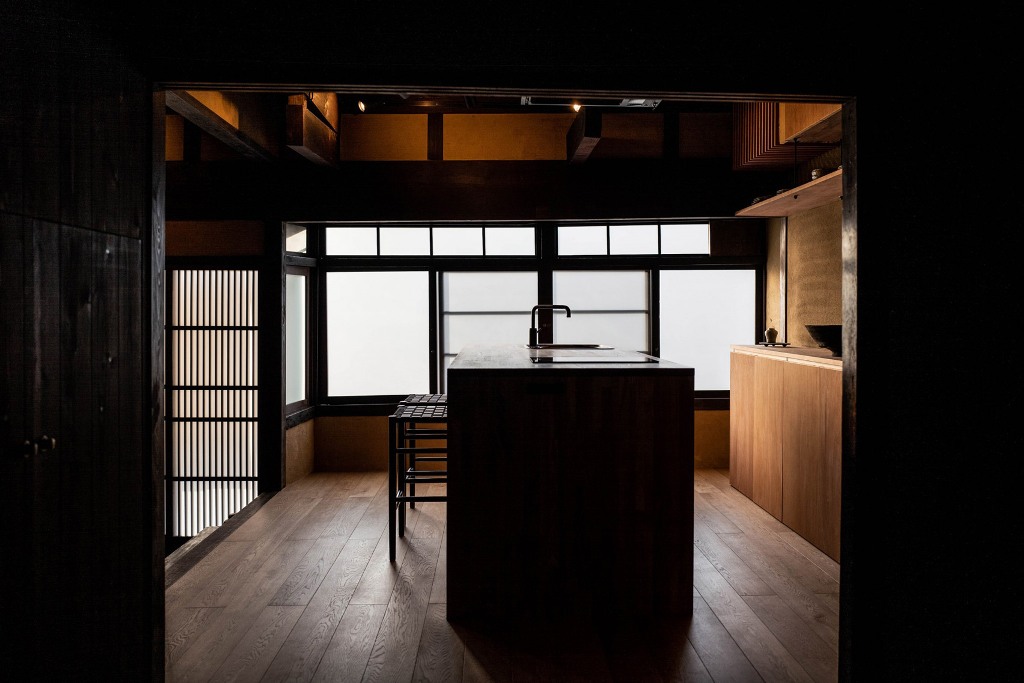 The kitchen is raised, made of wood and has a central island covered with layers of Urushi