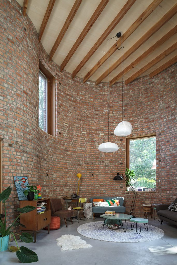 There are high ceilings with wooden beams, and the interiors are mid-century modern, with chic and cool furniture of muted colors, bright touches and pendant lamps that highlight the ceiling