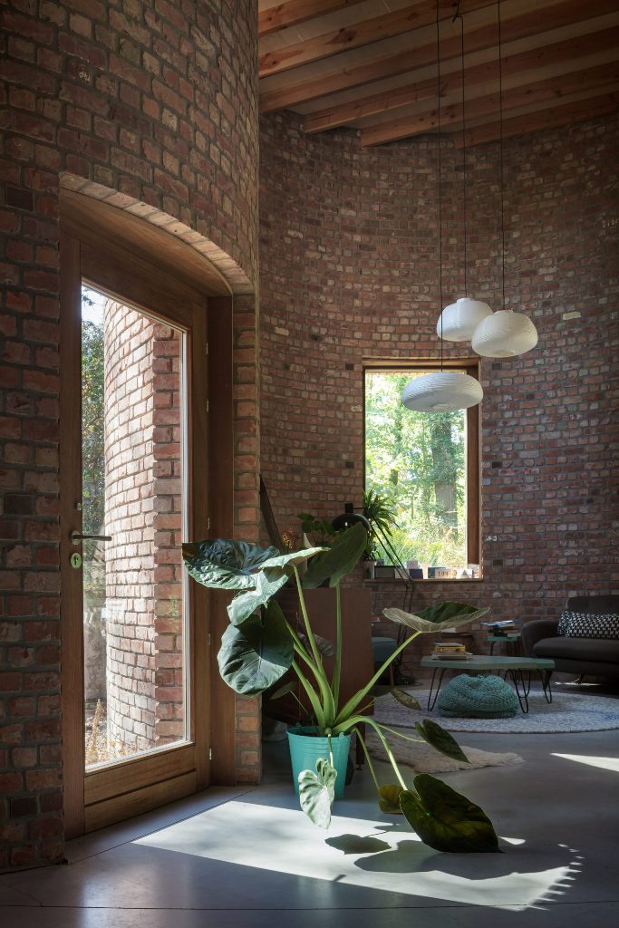 Glass doors and large windows brign much natural light in, there are statement plants add coziness here