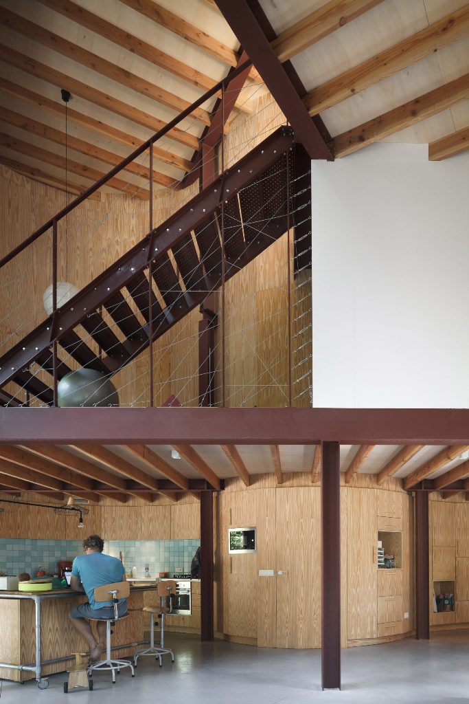 Wooden built-in-furniture follows the curving walls, look how creative the staircase space looks and how smart geometry was integrated here