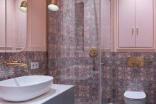 07 The bathroom is clad with bright patterned and grey ones on the floor and pendant lamps