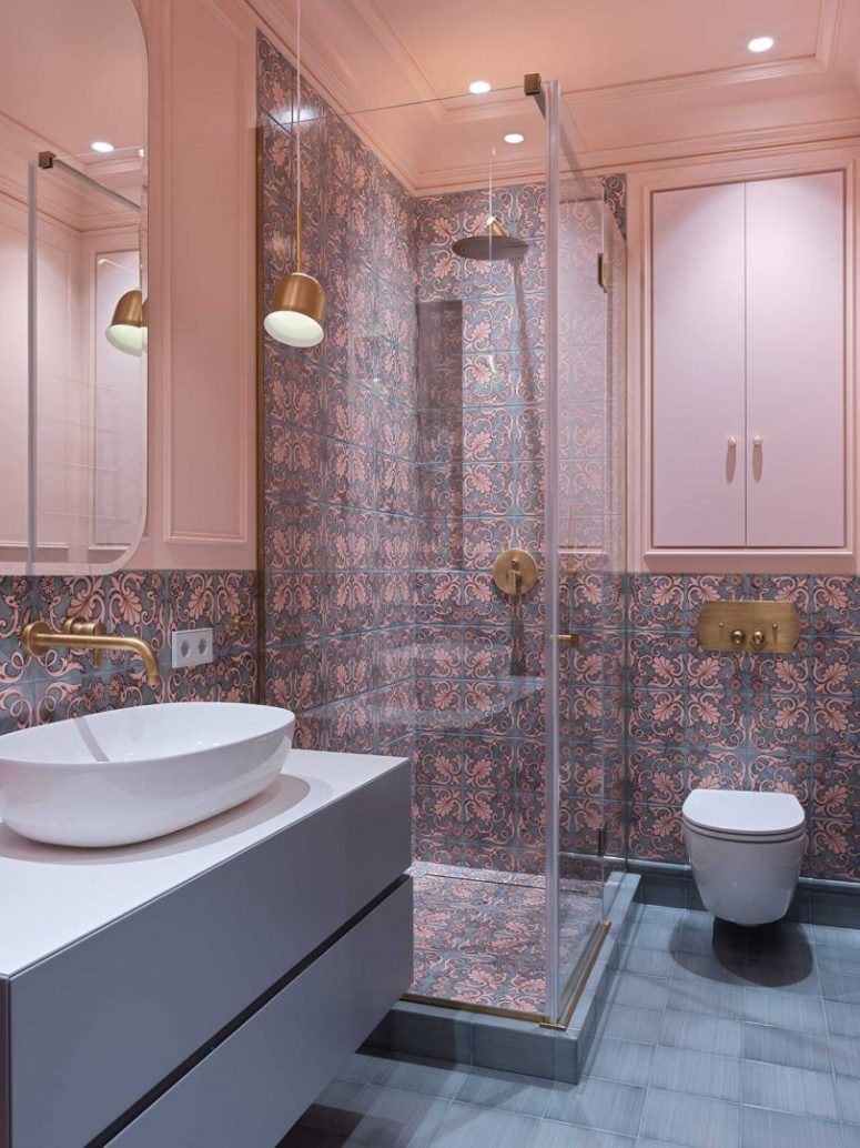 The bathroom is clad with bright patterned and grey ones on the floor and pendant lamps