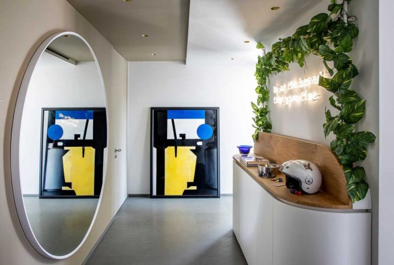 The entryway is done with a round mirror, a console, some greenery and a neon sign and looks amazing The entryway is done with a round mirror, a console, some greenery and a neon sign and looks amazing
