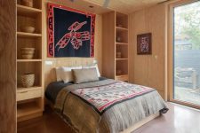 07 The second bedroom is done in the same style as the first one, with open shelving and bright boho textiles