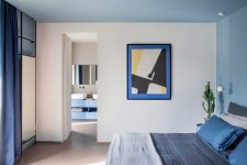 08 The bedroom features some cool furniture, navy and grey bedding and bold art