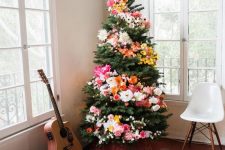 a Christmas tree decorated with blooms and lights is a unique boho chic idea to arise your inner flower child