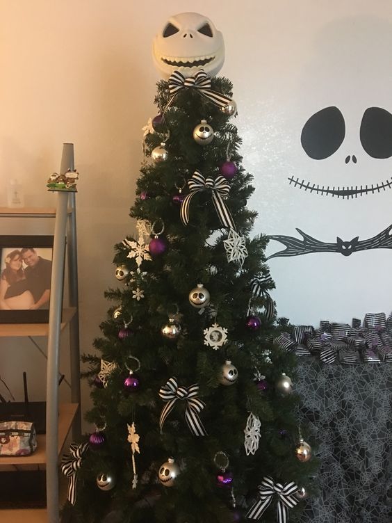 a Christmas tree with purple and gold ornaments and bows plus Jack Skellington decorations for more chic