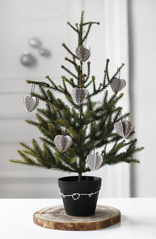 a Nordic tabletop Christmas tree in a pot decorated with grey and white 3D cardboard ornaments is a pretty and eco-friendly idea
