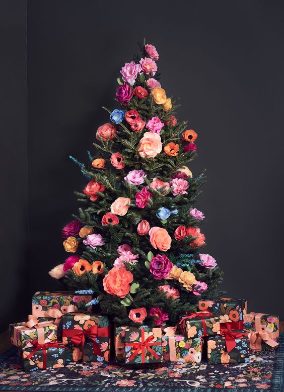 a beautiful and colorful Christmas tree decorated with faux blooms all the shades possible is a cool out of the box idea