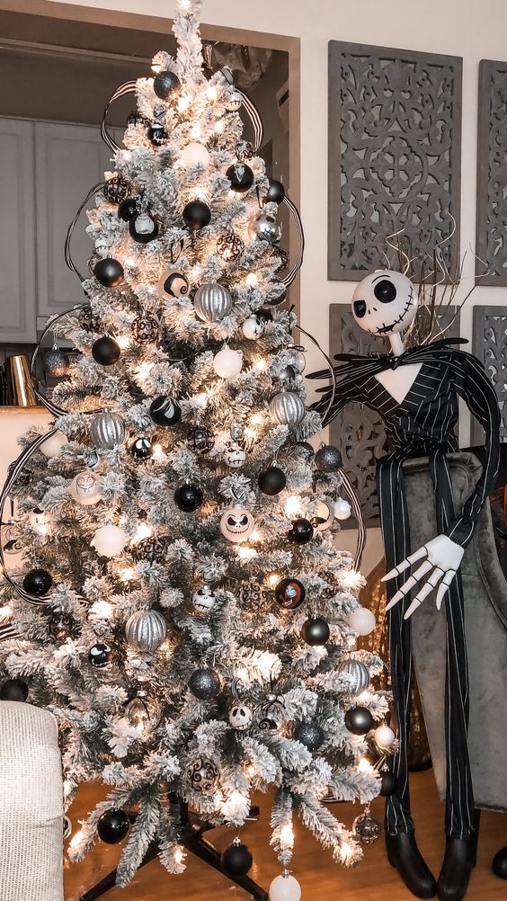 a beautiful grey Christmas tree with white, black and silver ornaments, Jack Skellington ones and his figure next to the tree