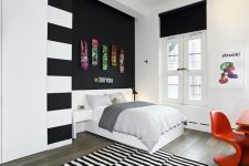 a black accent wall with colorful skates is a bold idea for a modern space, will fit a teenager room a lot