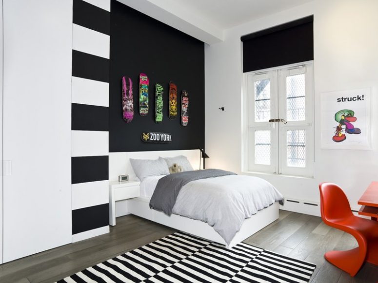 a black accent wall with colorful skates is a bold idea for a modern space, will fit a teenager room a lot