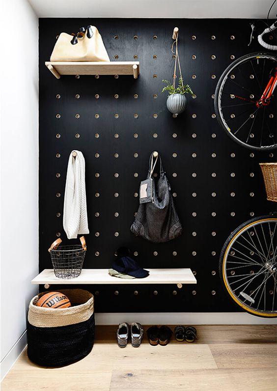 a black pegboard wall is ideal for an entryway, add shelves and hooks everywhere you want and make the space more functional