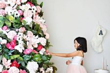 a gorgeous Christmas tree decorated with white, blush and red blooms and magnolia leaves plus a snowflake topper