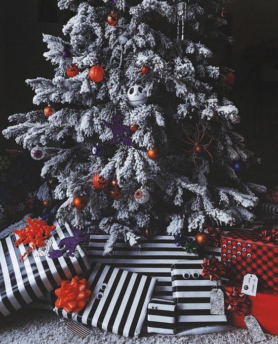 a gorgeous flocked Christmas tree with eyeball, pumpkin and Jack Skellington ornaments and lights plus striped gifts under it