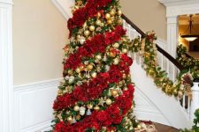 a jaw-dropping Christmas tree decorated with red roses and gold ornaments in between floral garlands is magnificent