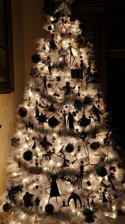 a lit up white Christmas tree with Nightmare Before Christmas ornaments and garlands is a lovely idea
