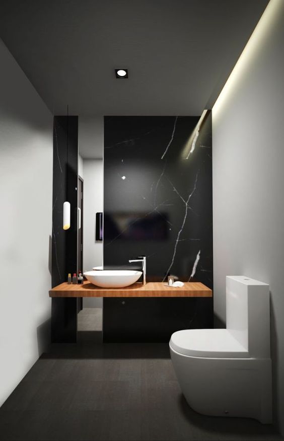 a refined black marble wall with white veins as a statement feature in a minimalist bathroom