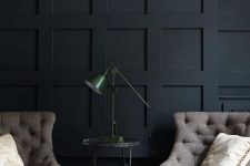 a refined black paneled wall plus vintage furniture create a chic and exquisite mood in this living room
