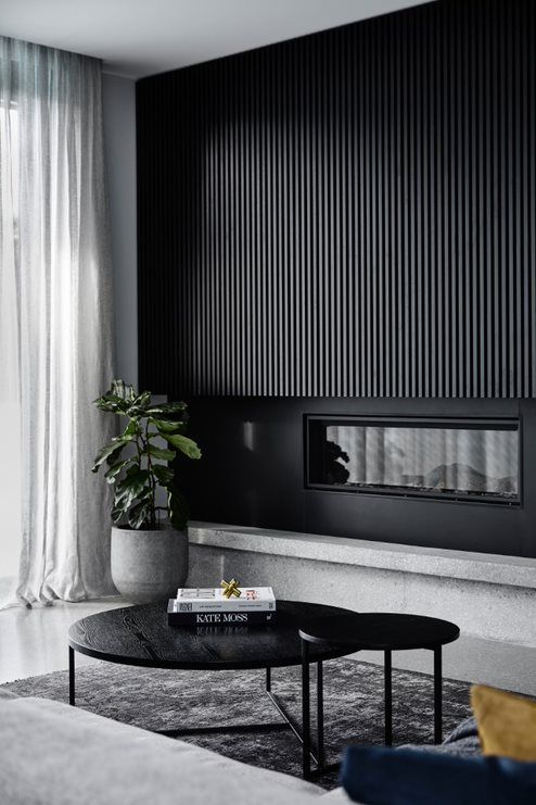 a sleek black wood slat wall with a built-in fireplace is a bold statement that will bring a dramatic touch to the space