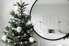 a small and simple tabletop Christmas tree with pompom garlands and large pompom ornaments for a Nordic feel