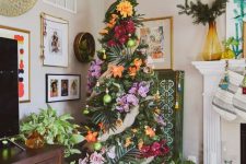 a tropical Christmas tree decorated with tropical leaves and super bold blooms for those who love tropics but can’t go there now