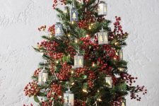 a vintage-inspired tabletop Christmas tree with berries, lights and tree-shaped mini lanterns is a lovely and bold idea