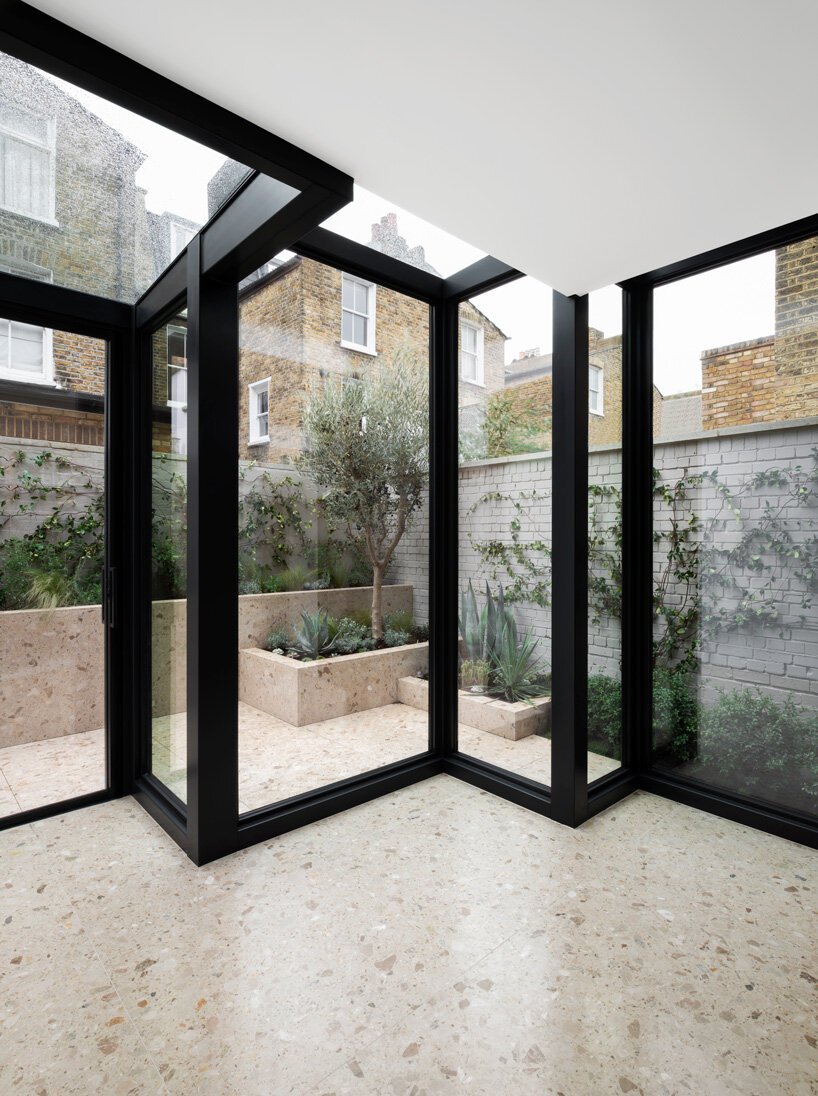 Glass walls offer much natural light and cool views of a private garden clad in terrazzo