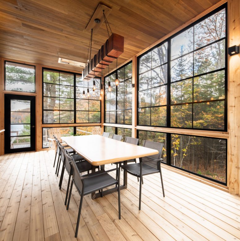 The dining space fully benefits from the views, with a wooden table, black meta chairs and an industrial chandelier The dining space fully benefits from the views, with a wooden table, black meta chairs and an industrial chandelier
