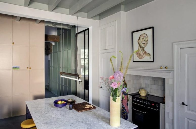 kitchen with an island that makes a statement The kitchen is done with neutral cabinetry, everything is hidden, there's a kitchen island and white tiles